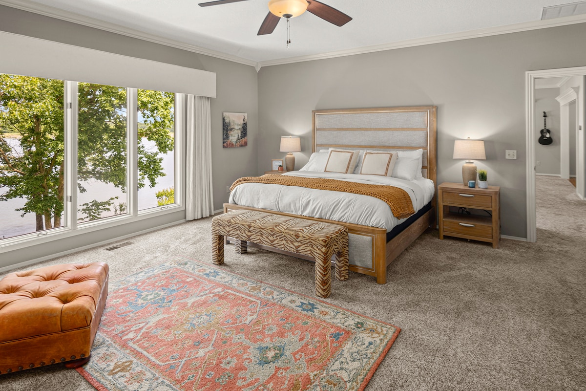 King size bedroom with a leather chair to relax, tv, and a crib. Has a full bathroom with bathtub and shower & private deck that overlooks the lake!