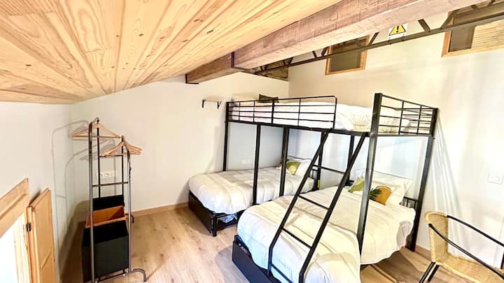 一张奇特的双层床，由一张高架双人床和两张单人床组成 