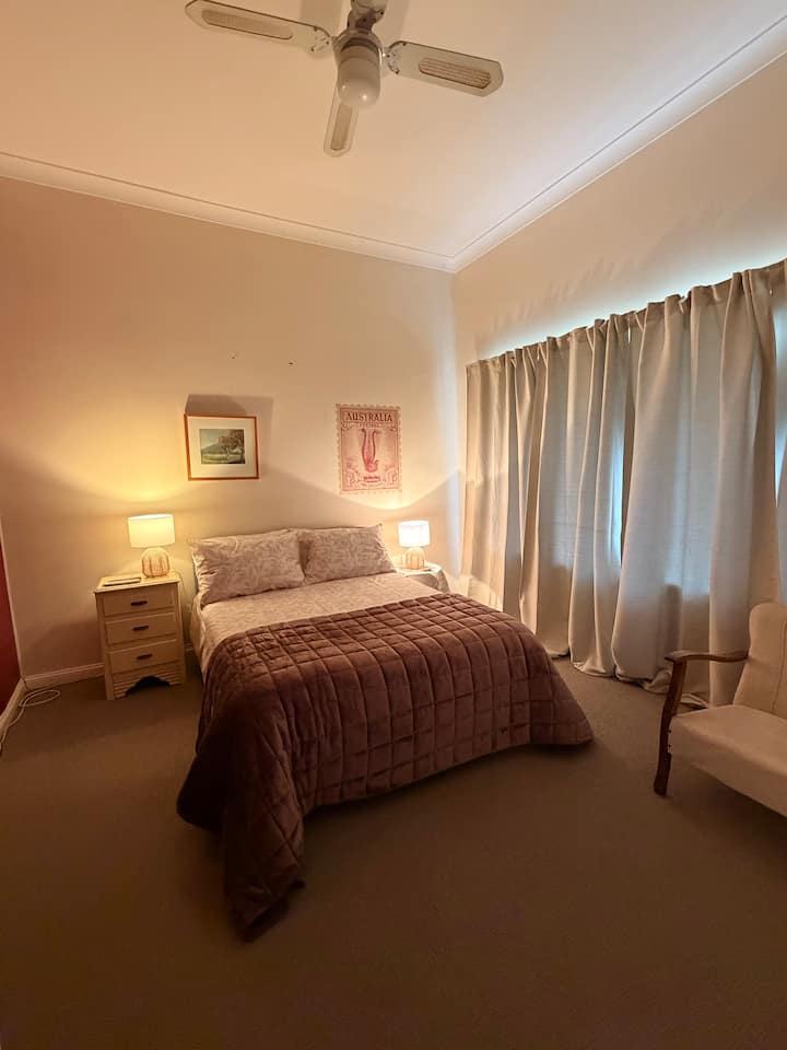 Double bed + bedside tables + bedside lamps + dress rack + coat hangers + bedroom chair + mirror + sheets & bedding + room darkening curtains.