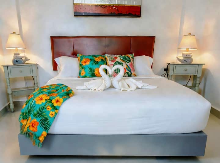 Your queen bed, made up before you even see the rest of the apartment.