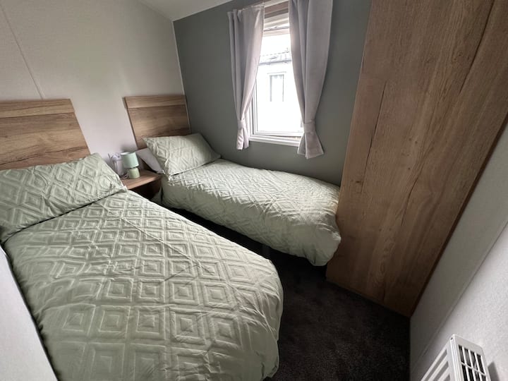Komfortable Einzelbetten, Einzelkleiderschrank und Kosmetikspiegel.