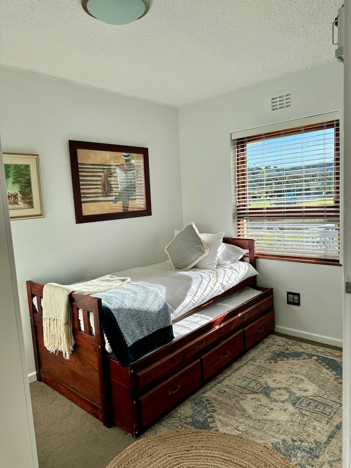 Aurinkoinen makuuhuone, jossa on yhden hengen vuode, jonka alla on ulosvedettävä yhden hengen vuode (täyspitkä)