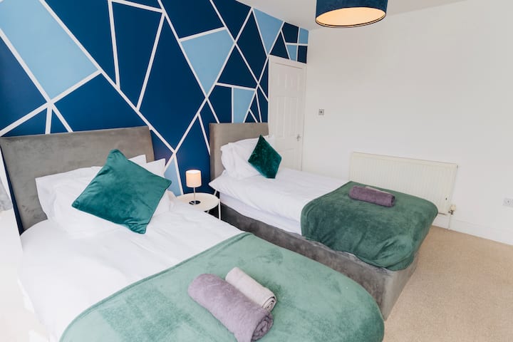 Dy krevate tek, abazhur pranë krevatit dhe tavolinë.
Përfshihen shtroja krevati të freskëta, peshqirë banje dhe peshqirë duarsh. 