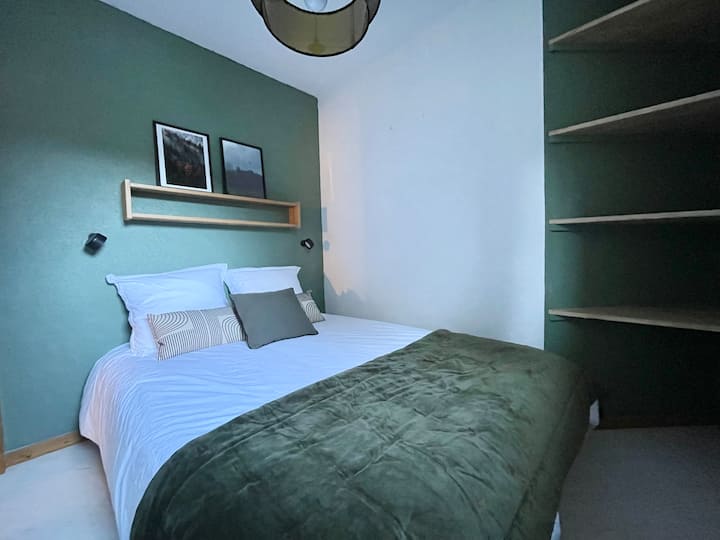 La chambre possède un lit double et des espaces de rangement 