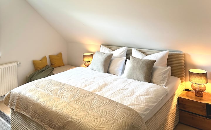 Rustgevende slaap in een groot, knus boxspringbed met hotelbeddengoed.