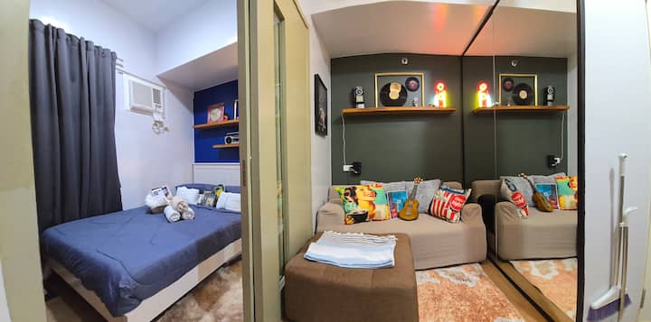 Panoramic or wide angle view of the bedroom and living room area. 
