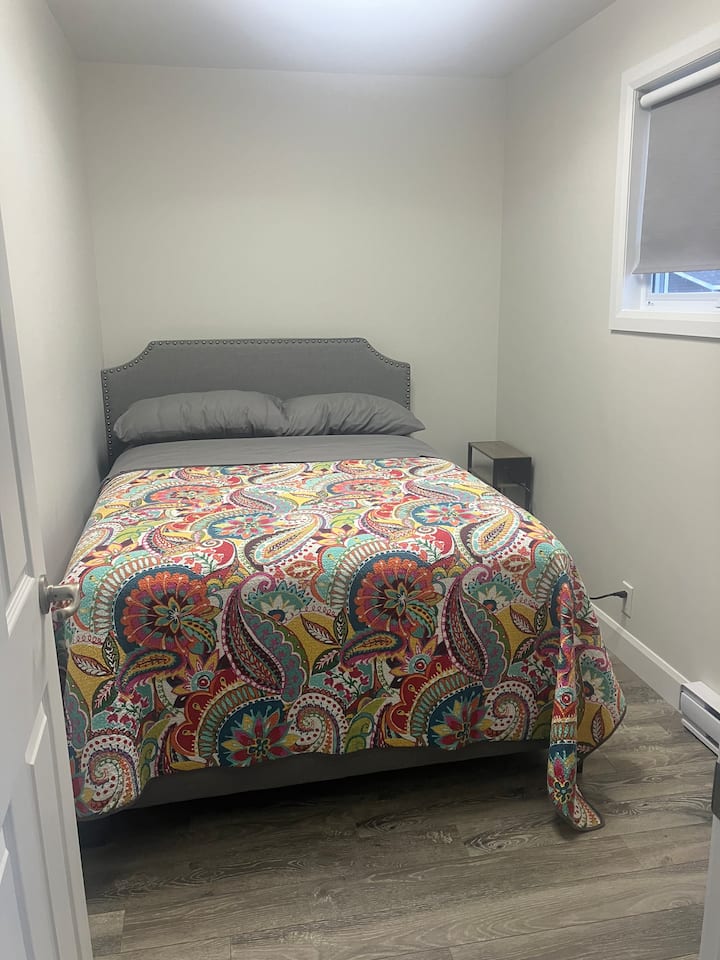 全新豪华双人床、枕头、毯子和床单，边桌有充电口和插头  
还有一个小梳妆台