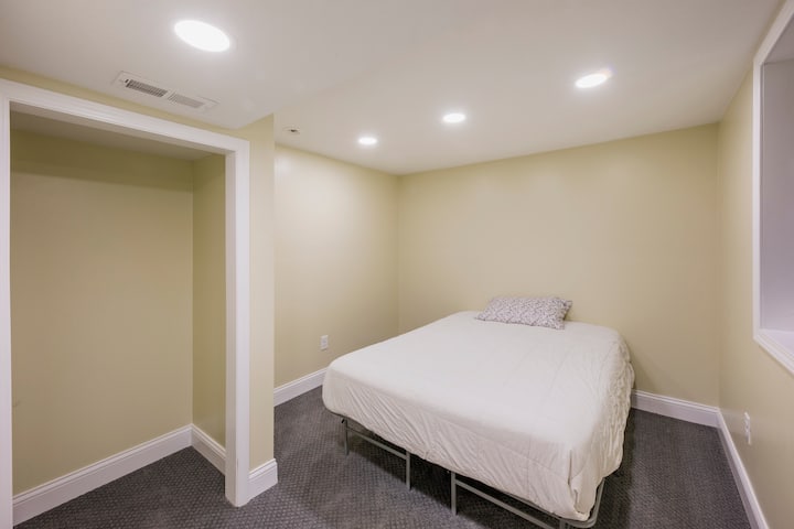 Cama tamaño queen en la recámara del sótano, con puerta que se puede cerrar.