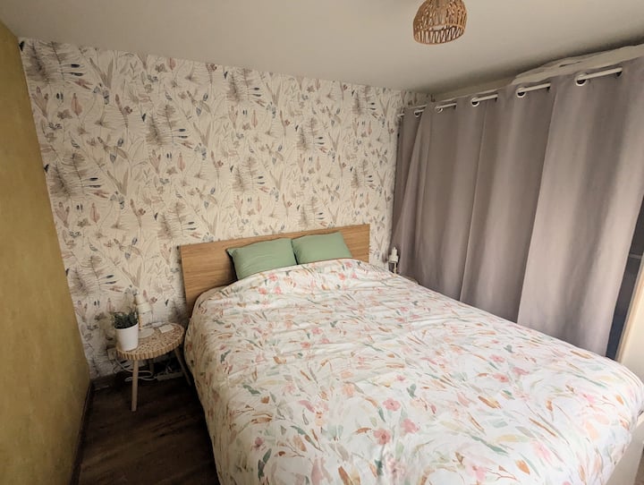 cama principal en habitación de 9 m2 separada con dos mesitas de noche 