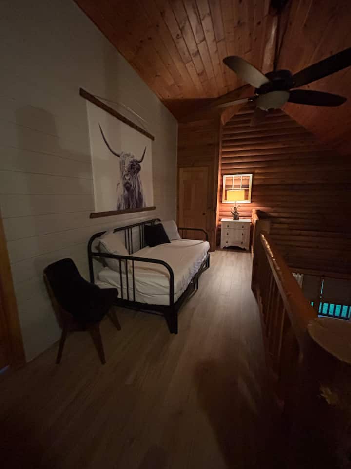 هذه هي المنطقة العلوية.  يمكن أن يصبح السرير سريرًا بالحجم الكامل (سريران متماثلان إلى سرير كامل) ولكن نظرًا للموقع الحالي، فإنه يناسب فقط سريرًا متماثلًا (من المحتمل نقل السرير من هذا المسكن في المستقبل القريب).  هذا السرير في أعلى الدرج وفي الدور العلوي.