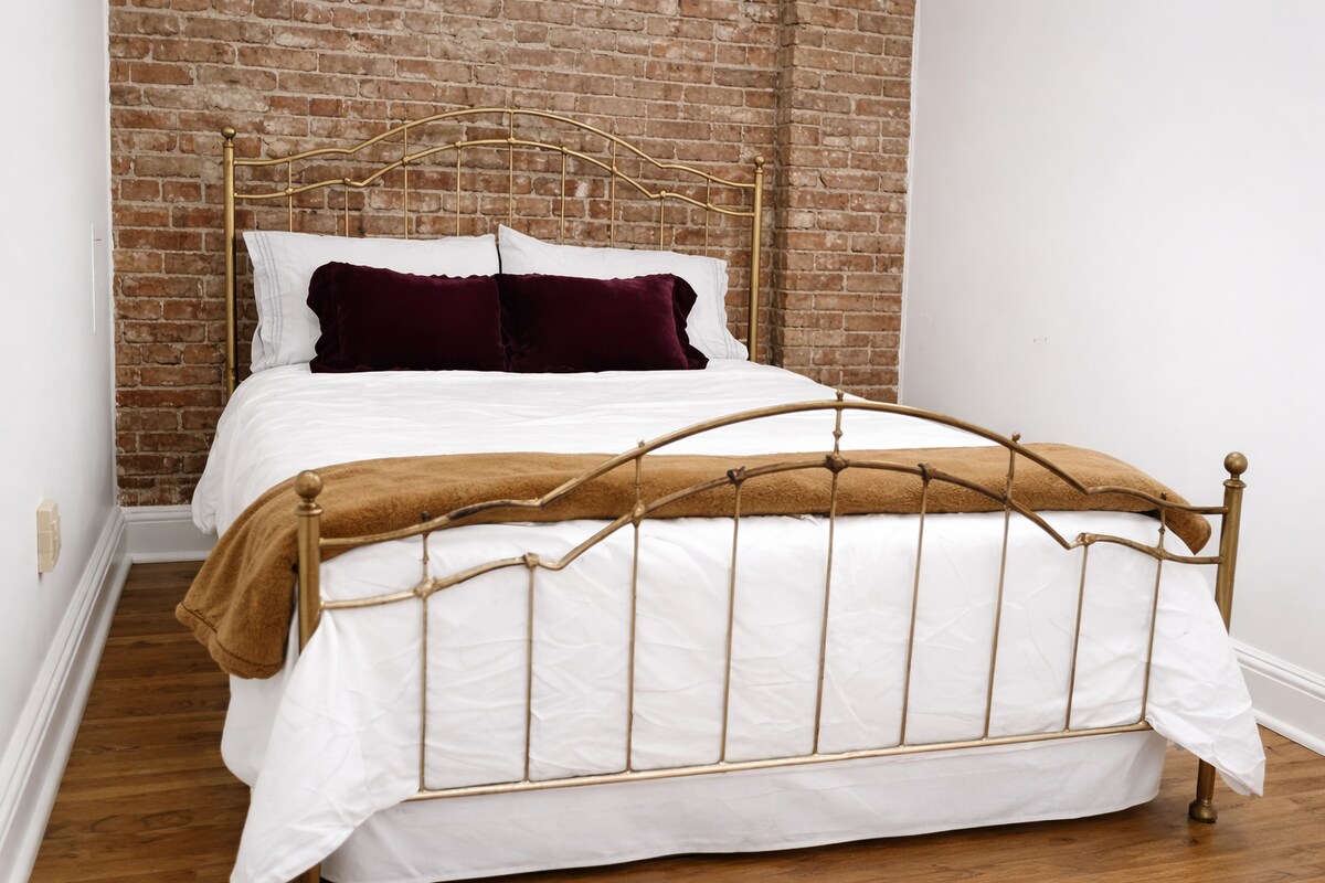 Útulný roh s manželskou posteľou a odkrytou tehlou