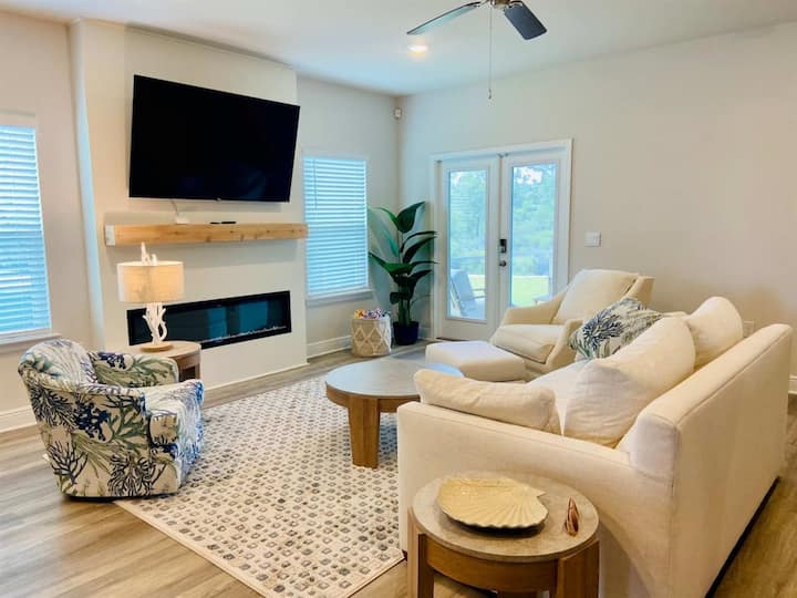 Spacious living area with comfy seating, an electric fireplace, and 70” Roku TV—ideal for movie nights after beach days.