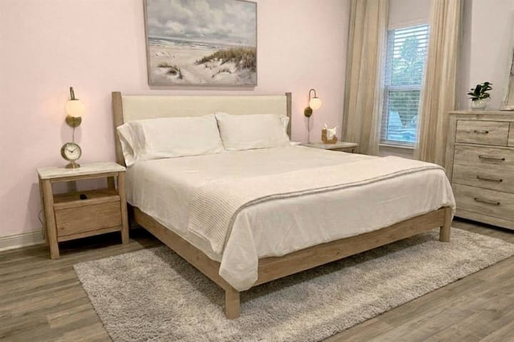 Luxurious primary suite with king bed, walk-in closet, and ensuite bath featuring double vanity.