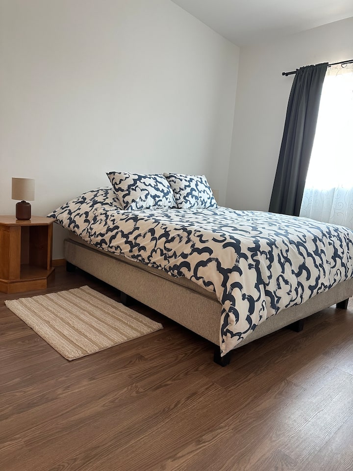 Tapetes, burós y lámparas de noche disponibles a ambos lados de la cama