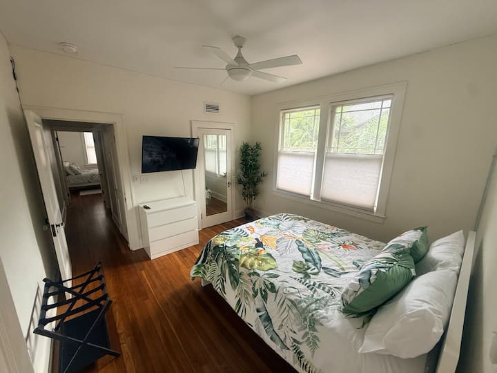 Dormitorio central con cama tamaño queen, ventilador de techo con luz, armario, estante para equipaje, TV, juego de cajones, cargador de teléfono multipuerto (trae tu propio cable de carga). Almohada adicional en el armario.