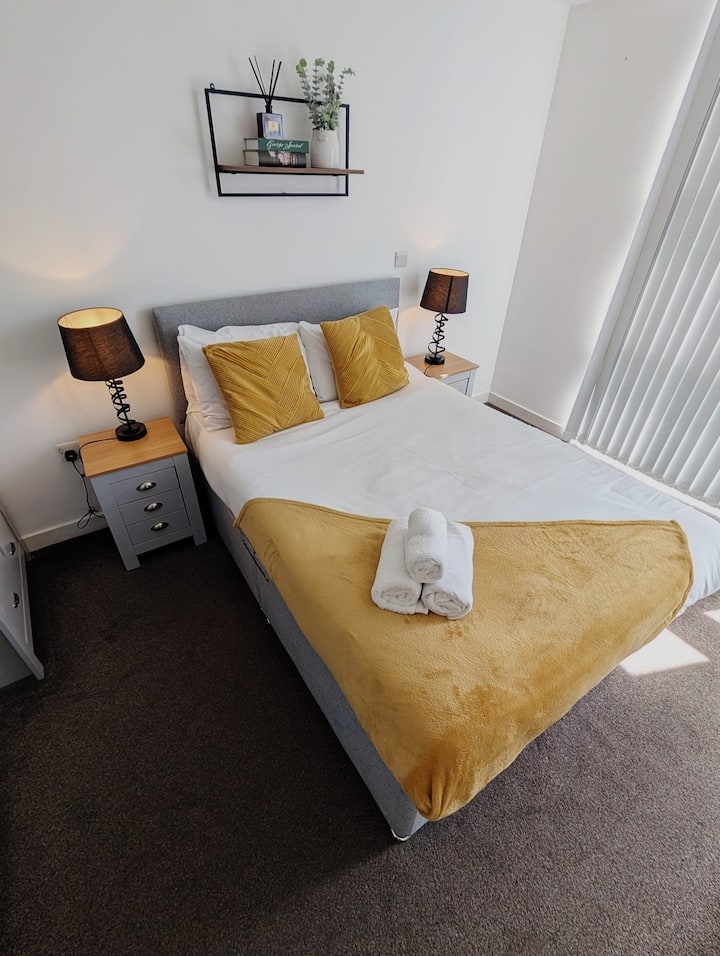 Un sogno estetico giallo e grigio, completo di biancheria candida e fresca, soffici coperte e lampade che irradiano puro relax.