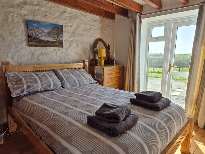 Bedroom 1 with double bed.
A glass door opens out onto the front of the cottage