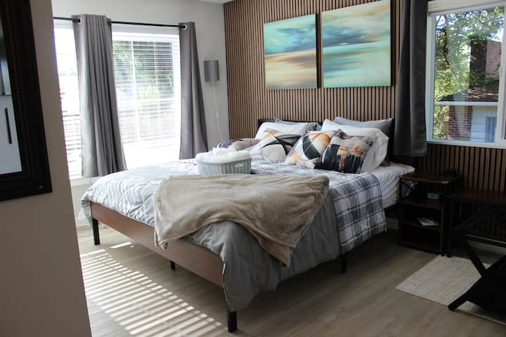 Primaire suite met eigen bad, kingsize bed, grote ramen met verduisteringsgordijnen, overvloedig natuurlijk licht, een ruime kast en een gemonteerde smart-tv. Beide zijden van het bed hebben speciale stopcontacten met USB en USB-C opladen.