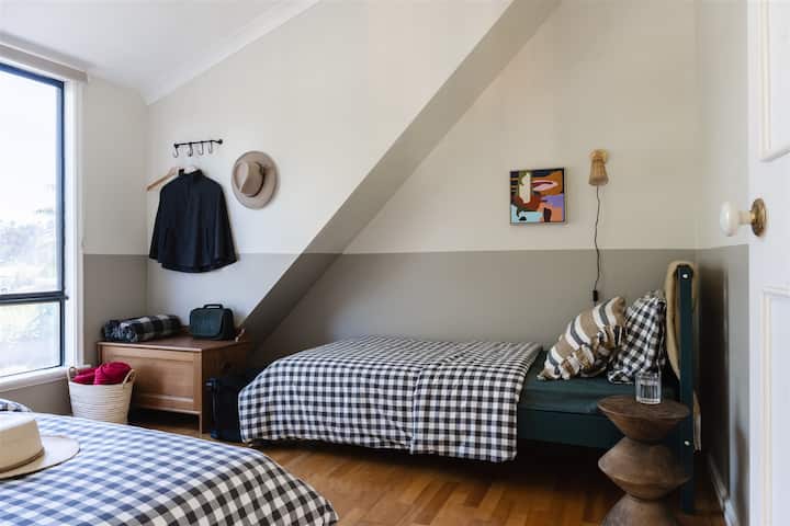 Located on the upper level, adjacent to the library lounge, powder room with toilet and Bedroom 2 -  the twin bedroom features high quality linens and original artwork.
