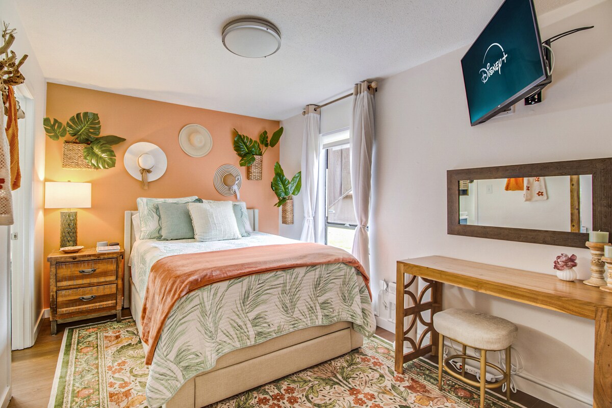 בחדר השינה יש מיטת קווין סייז גדולה, מראה באורך מלא, פינת עבודה ייעודית וטלוויזיית Roku עם מסך שטוח.