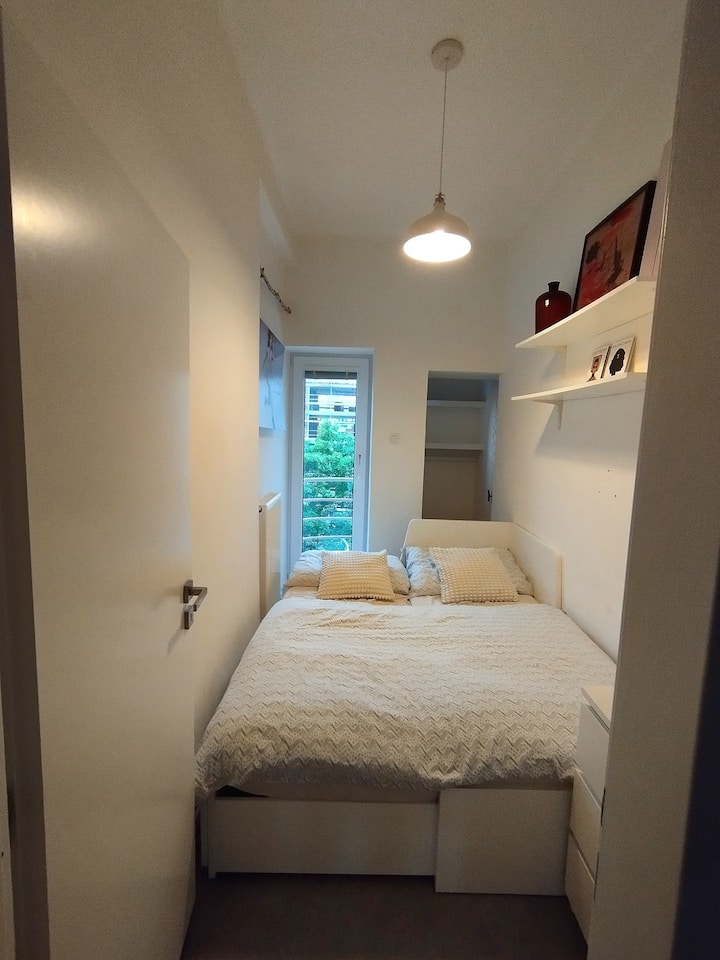 Manja spavaća soba okrenuta prema mirnom dvorištu. Tu je komoda za odlaganje odjeće, kao i garderoba s vješalicama i policama.
Iza kreveta su ulazna vrata na balkon.