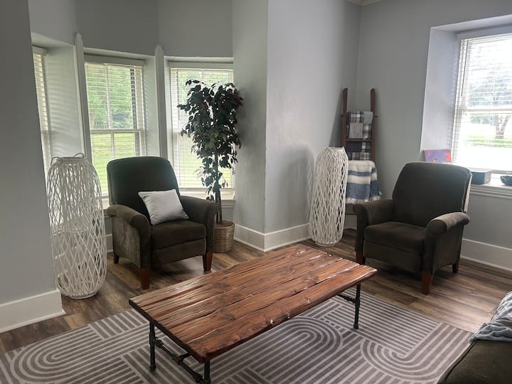 Hay un sofá y 2 sillones reclinables.  El único televisor de este alojamiento está en esta habitación.  