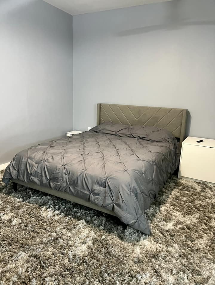 Bračni krevet s poplunom i noćnim ormarićem na svilenom tepihu 