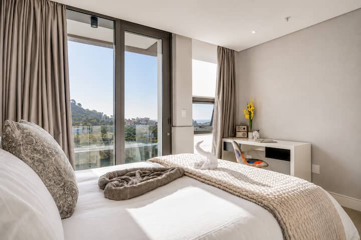 Bedroom Retreat: Wake up to soft natural light and calming city views from this beautifully styled bedroom, offering a peaceful setting with fresh linens, gentle tones, and a relaxing place to unwind.