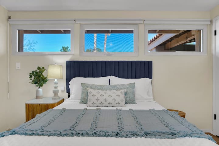 Un dormitorio luminoso adornado con muebles con detalles de mármol, cortinas opacas, ropa de cama de primera calidad y un televisor en la habitación. Un espacioso armario mantiene tus pertenencias organizadas, mientras que el ambiente acogedor y refinado crea el refugio perfecto para relajarte.