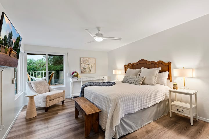 Relájate en una lujosa cama tamaño king rodeada de grandes y luminosas ventanas, exuberantes vistas al campo de golf, persianas opacas y TV.