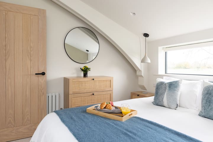 Room 2 offers useful storage with a spacious chest of drawers, while the large wall mirror adds both practicality and a bright, elegant feel to the room