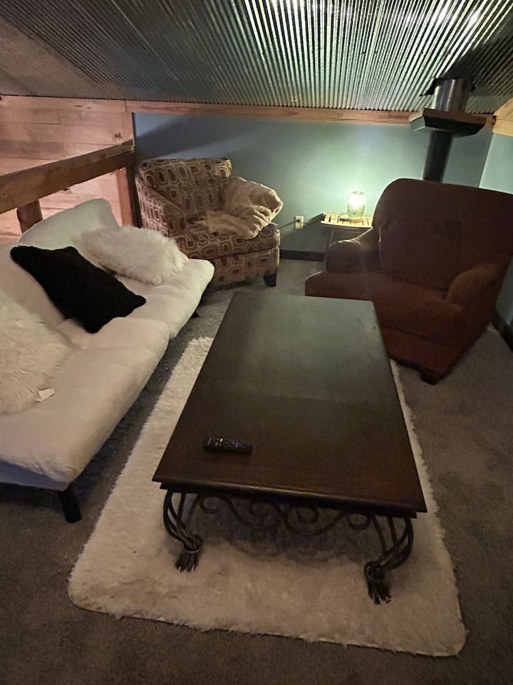 Ovo je cool mali prostor za druženje, savršen za tinejdžere ili djecu ili se može koristiti kao drugi dnevni boravak.   Ima pametni televizor i futon, a krevet za jednu osobu nalazi se na drugoj strani sobe. Ovo je loft nasuprot spavaćeg prostora s tri kreveta.  