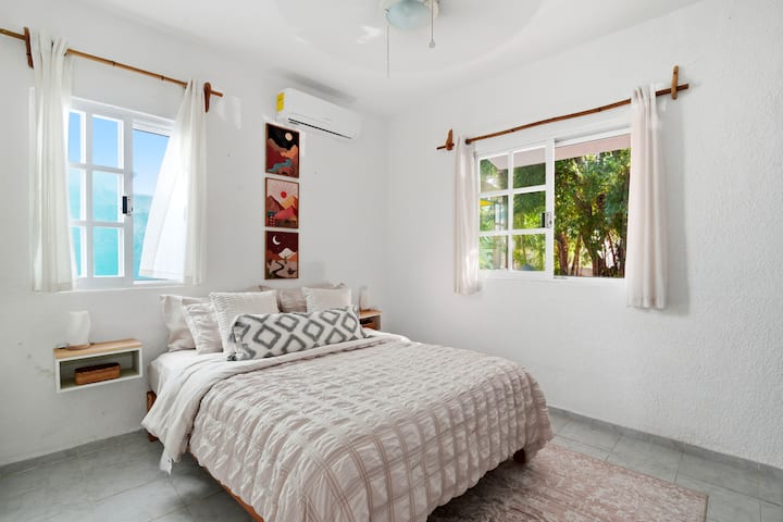 El segundo dormitorio cuenta con una cómoda cama tamaño queen con almohadas suaves, además de aire acondicionado y un ventilador de techo para una noche fresca y reparadora.