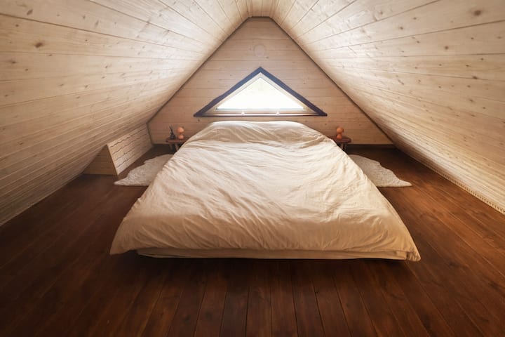 Upstairs sleeping loft with a king size bed (180x200cm) that can be turned into two separate single beds (90x200cm). Additionally you'll find 2 bedside tables, 2 small bedside lights, a storage chest and couple of hooks with hangers.
