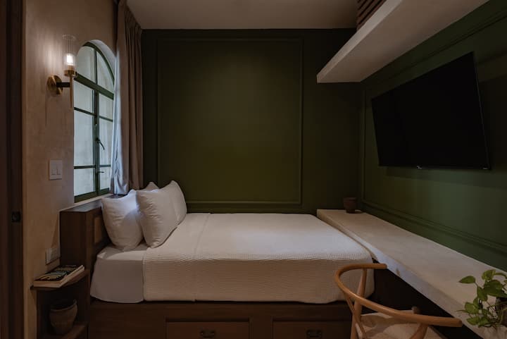 Minimalist bedroom with pistachio green wall; Pistachio House in Campeche