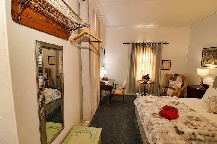 Cama tamaño queen, escritorio y silla, silla con alas y calentador de panel de pared.