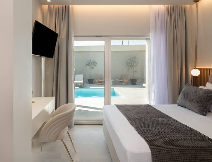 Luxury Poolside Retreat
Dhomë gjumi elegante kryesore me pamje nga pishina në një vilë moderne Airbnb në Kretë. Ka shtroja prej pelushi, ndriçim ambienti dhe një hapësirë pune elegante. Ideale për pushime romantike, qëndrime luksoze ose pushime në distancë.