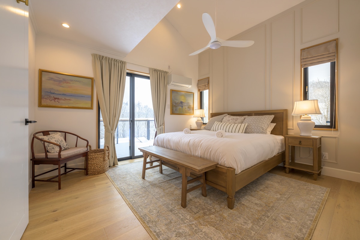 غرفة نوم رئيسية واسعة/أرضيات خشبية وسرير كينج واسع ومرتبة مريحة للغاية. مفروشات فاخرة، لوحة جدارية مميزة، أثاث مخصص، وإضاءة مصممة. ستائر تعتيم + ستائر. حمام داخلي مع دشين/غرفة بخار وحمام.