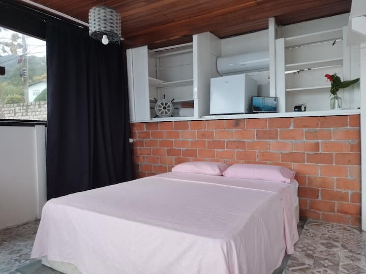 Chambre avec un lit double, un espace de travail informatique et une vue dégagée sur la mer.