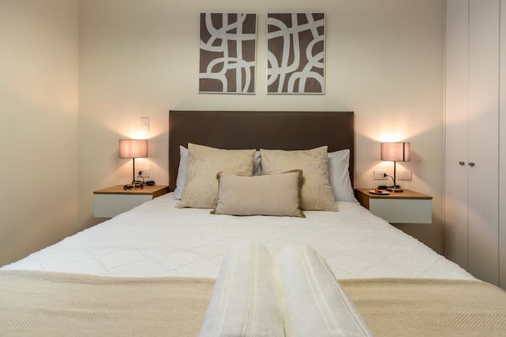 Dormitorio con cama queen y sábanas premium