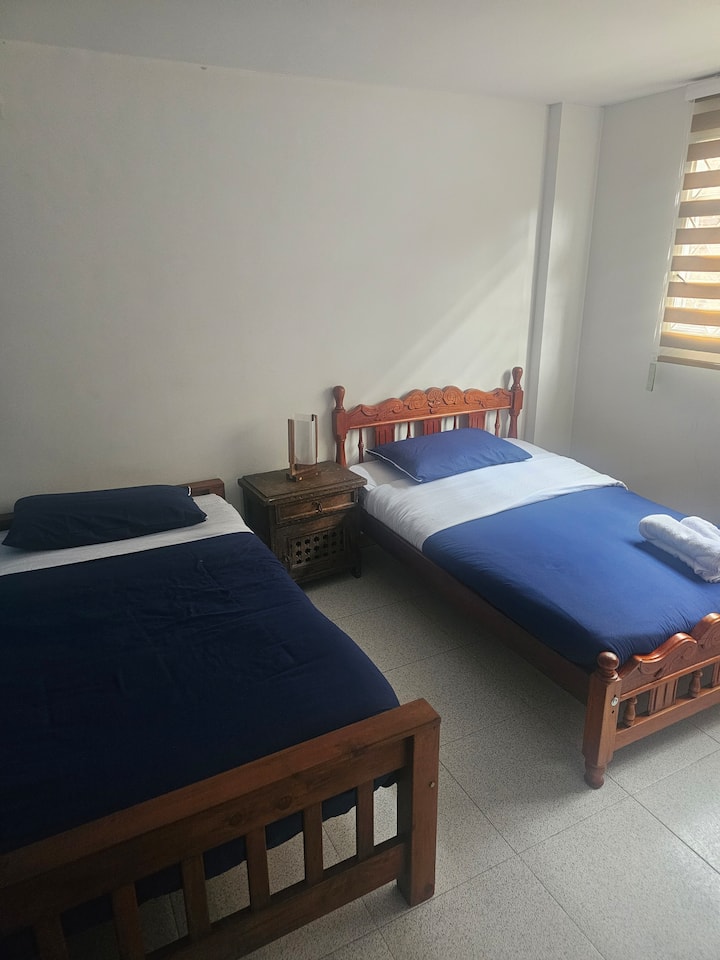 Ფართო და ნათელი ოთახი ორი კომფორტული საწოლით, იდეალურია ფეხით სიარულის ან მუშაობის შემდეგ დასვენებისთვის.