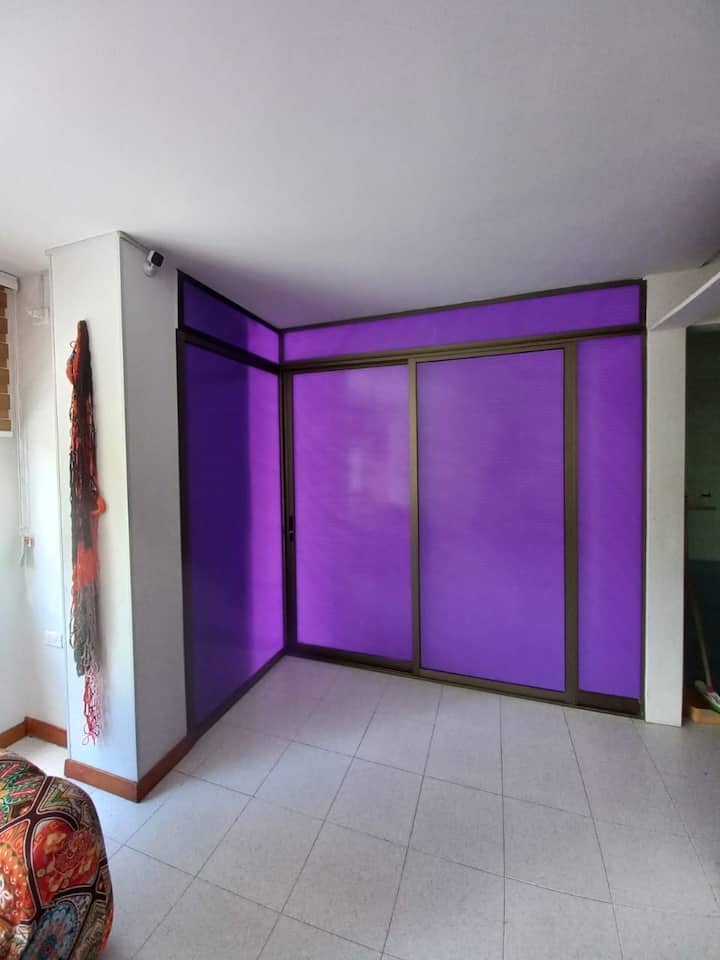 Pequeña pero encantadora sala, con colores suaves y detalles vibrantes que crean un ambiente cálido.