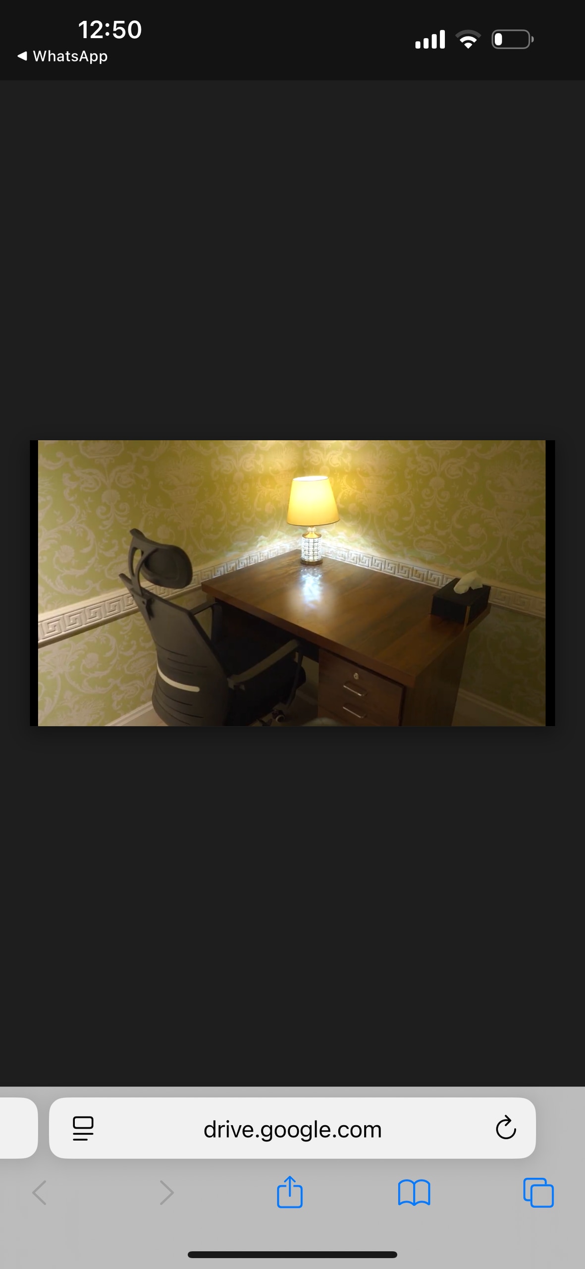 A small workspace is featured, displaying a wooden desk accompanied by a comfortable office chair. A lamp casts a warm glow, illuminating the space against the backdrop of light green patterned wallpaper.
