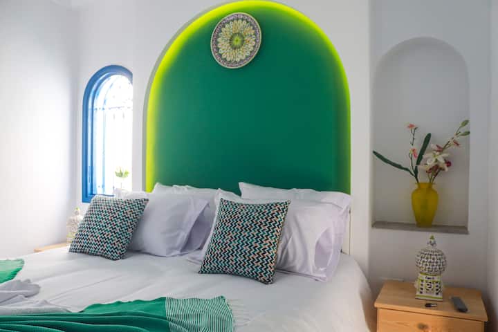Acogedora habitación doble de estilo mediterráneo oriental con una cómoda cama doble y un evocador arco circular iluminado. Los detalles cuidados y los colores armoniosos crean un ambiente relajado y agradable para llegar y descansar.