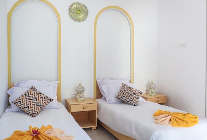 Habitación doble luminosa con dos cómodas camas individuales, elegantes arcos redondeados y diseño mediterráneo-oriental. Los detalles cuidados y los toques de colores cálidos crean un ambiente relajado, ideal para amigos, familias o personas que viajan juntas.