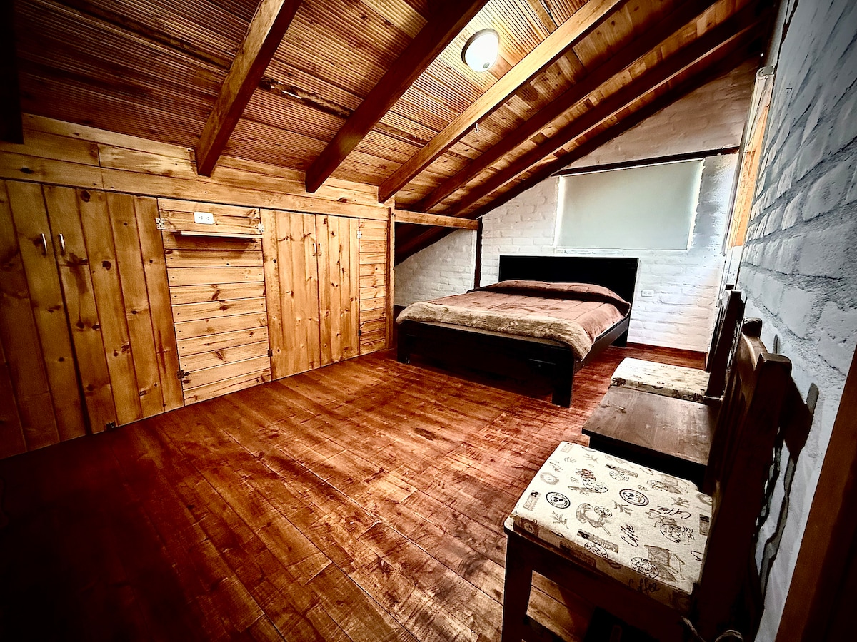 חדר זוגי עם מיטה של 2.5 מיטות מצוידות בסדינים ובשמיכות תרמיות. 