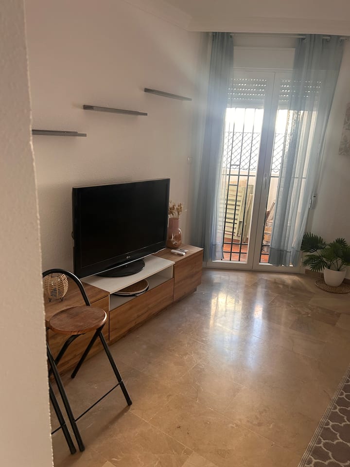 Grand salon avec cheminée, ventilateur de plafond, canapé-lit italien, table à manger avec 6 chaises 