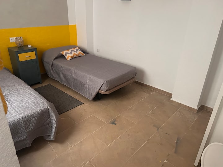 Belle chambre avec deux lits de 90 avec placard, télévision, table de chevet et coin bureau.