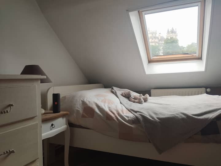 Cama de matrimonio con vistas al castillo, un armario empotrado, una cómoda, un escritorio y un televisor con videoconsola