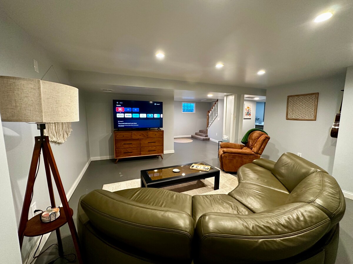 Kelderwoonkamer met smart-tv. Speciale werkruimte in de achterste hoek.